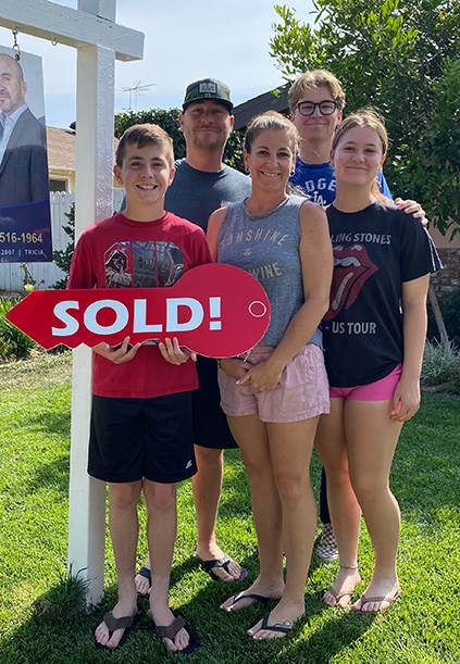 family holding up the sold sign from the real estate toolbox