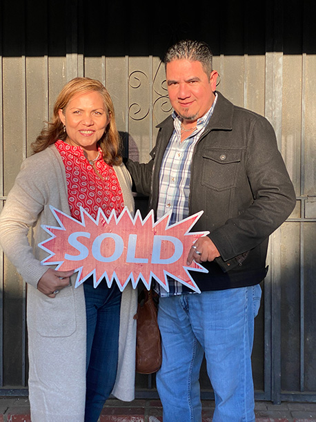 couple holding Sold sign from Steve Hise and Tricia Garcia